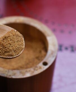 brown wooden round container on pink textile