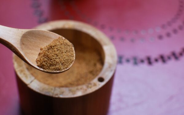 brown wooden round container on pink textile
