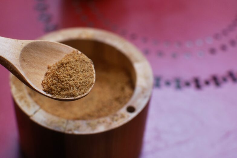 brown wooden round container on pink textile