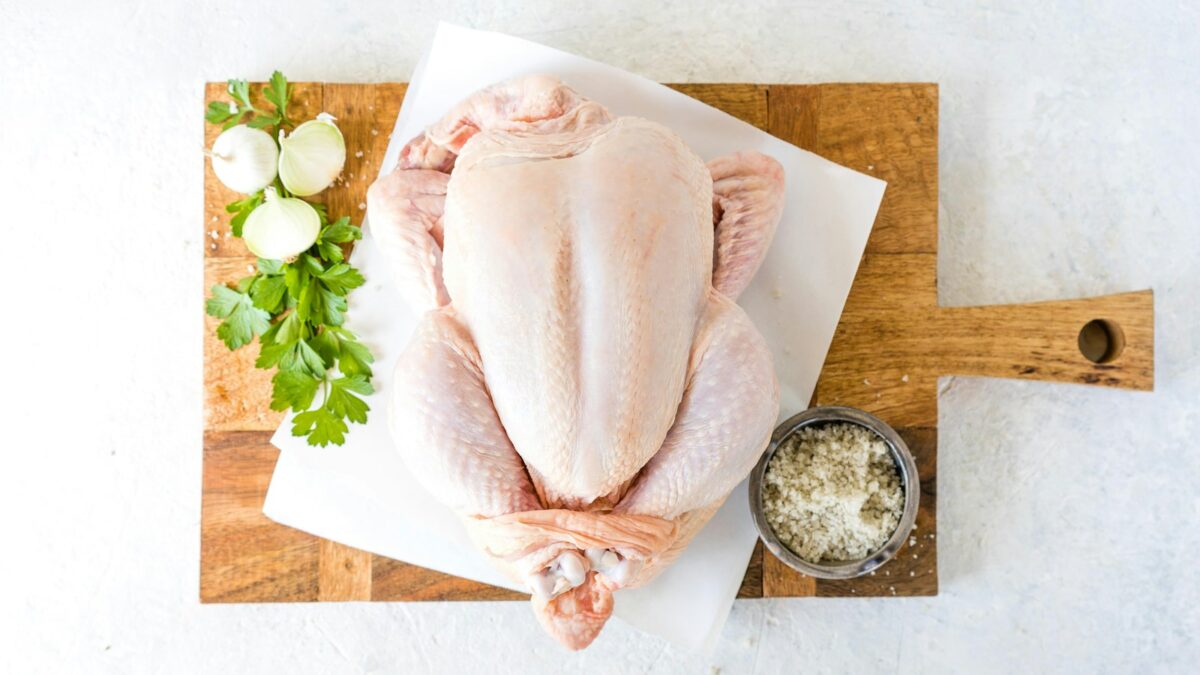 a raw chicken sitting on top of a cutting board