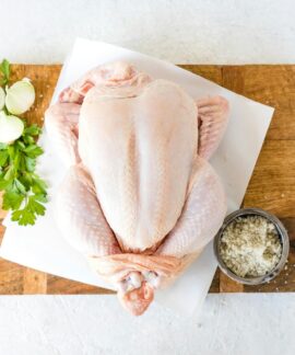 a raw chicken sitting on top of a cutting board