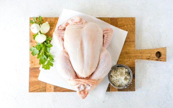 a raw chicken sitting on top of a cutting board