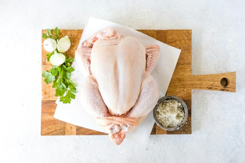 a raw chicken sitting on top of a cutting board