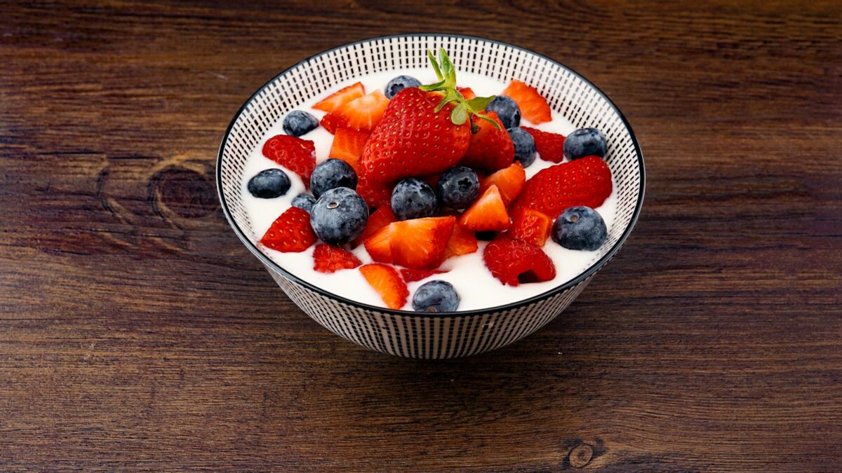 strawberry and blackberries on top of brown table