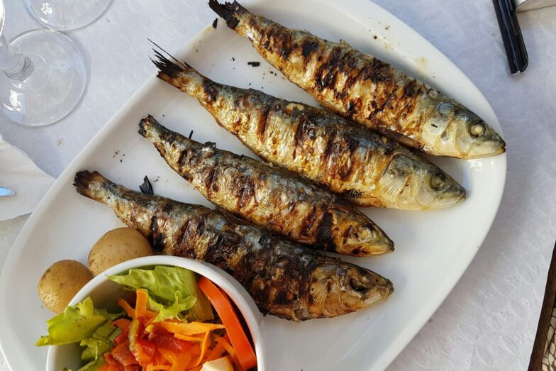 grilled fish with vegetable salad on white ceramic plate