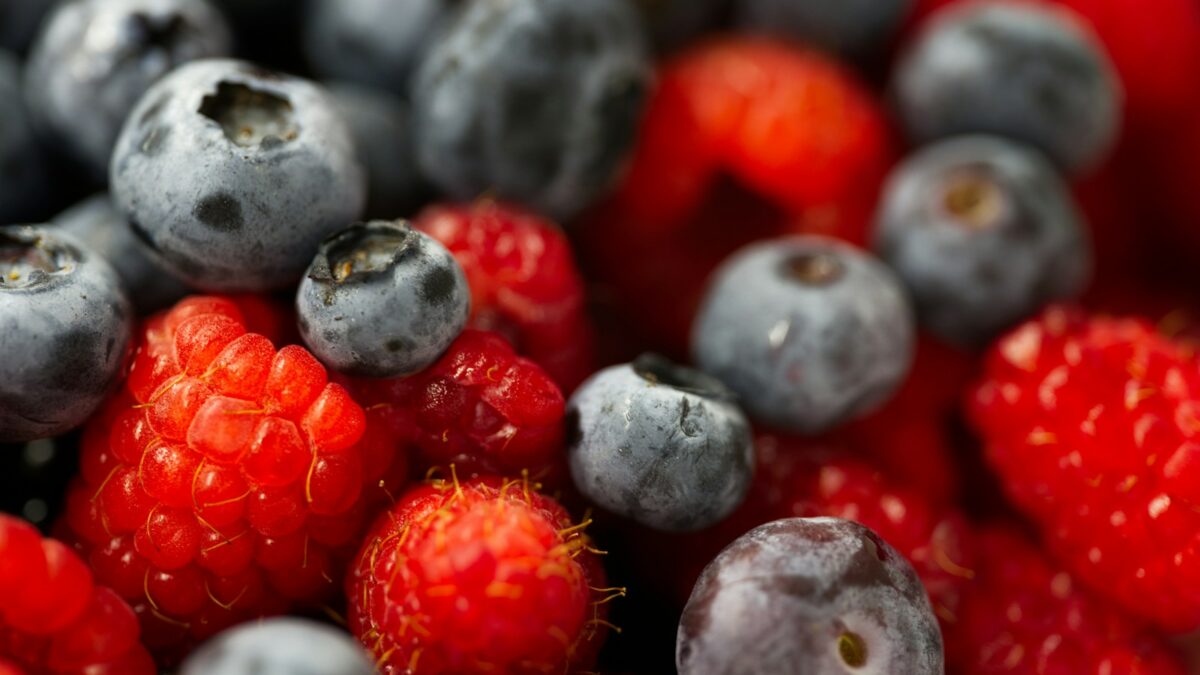 A close up of berries and blueberries in a bowl
