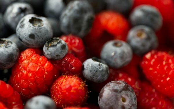 A close up of berries and blueberries in a bowl