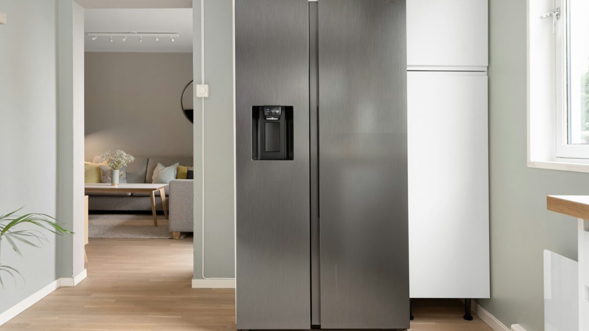 A refrigerator in a kitchen next to a window