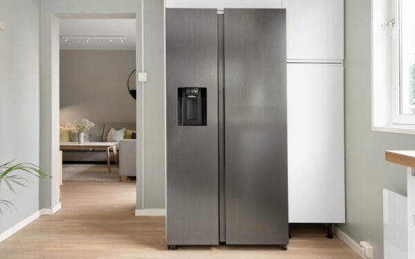 A refrigerator in a kitchen next to a window
