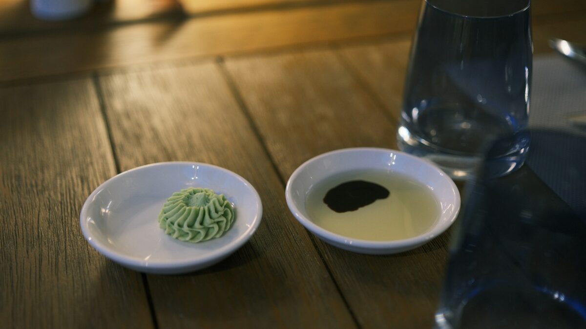 Two small dishes with sauce and wasabi