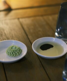 Two small dishes with sauce and wasabi