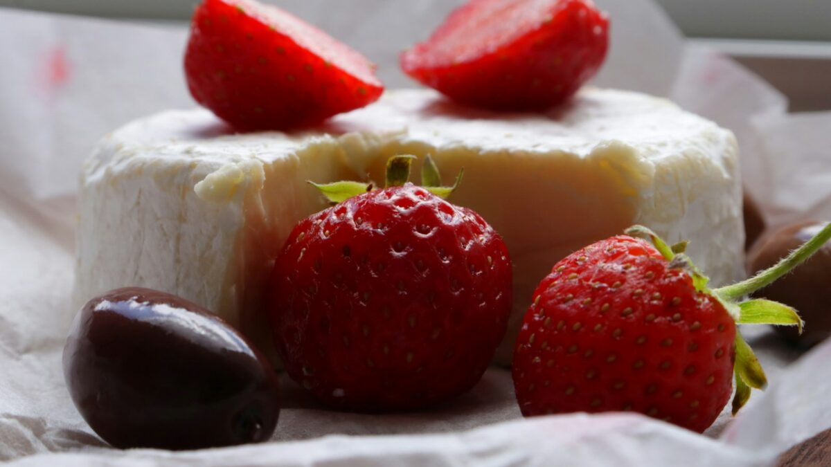 Strawberries, cheese, and a chocolate truffle are shown.