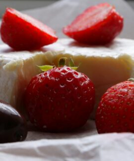 Strawberries, cheese, and a chocolate truffle are shown.