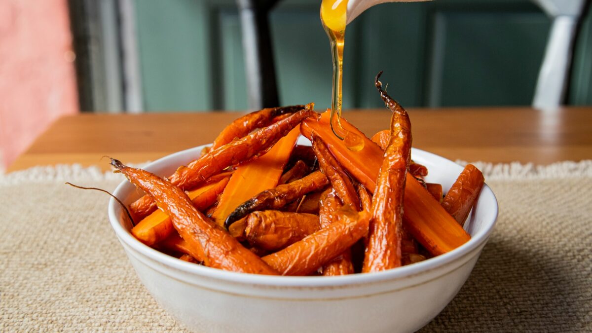 a white bowl filled with carrots sitting on top of a table