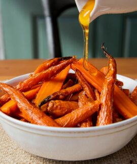 a white bowl filled with carrots sitting on top of a table