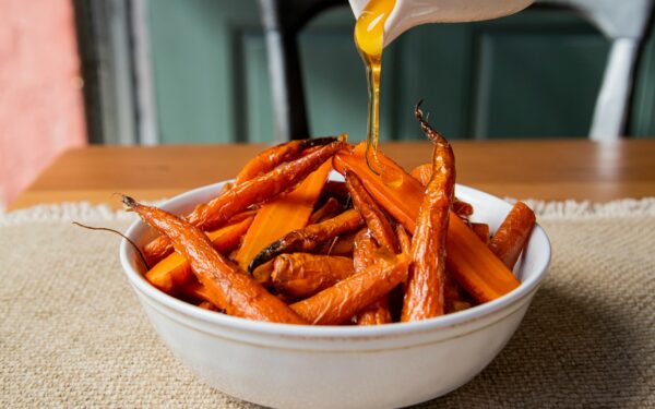 a white bowl filled with carrots sitting on top of a table