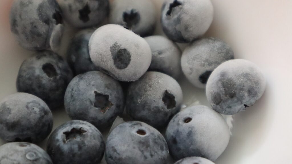 a white bowl filled with blueberries covered in frosting