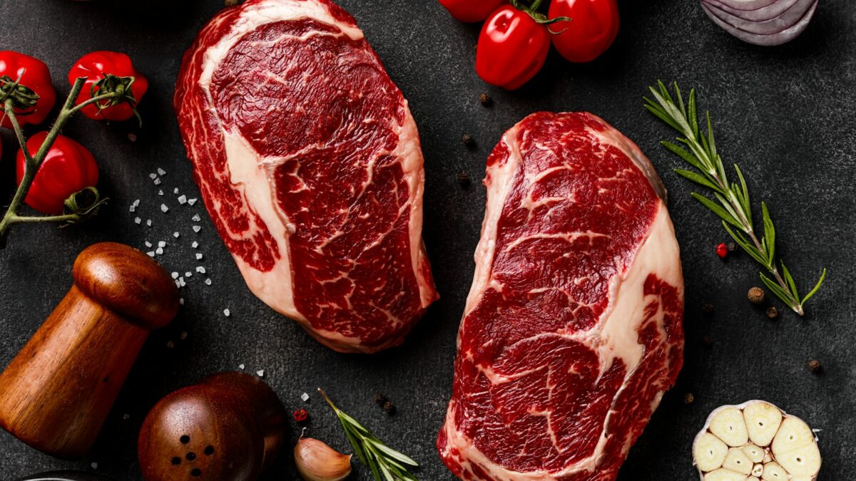 a couple of steaks sitting on top of a table