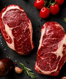a couple of steaks sitting on top of a table