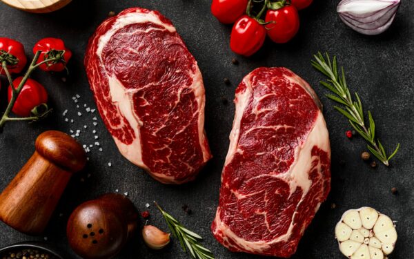a couple of steaks sitting on top of a table