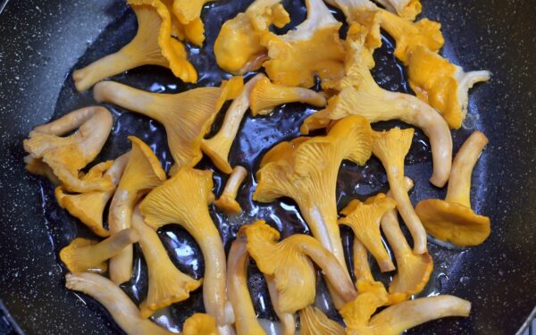 a frying pan filled with lots of yellow mushrooms