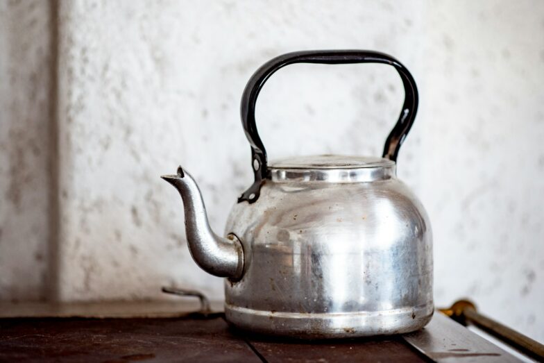 stainless steel kettle on brown wooden table