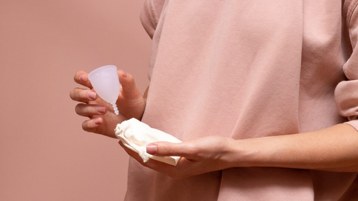 person in pink long sleeve shirt holding white heart ornament