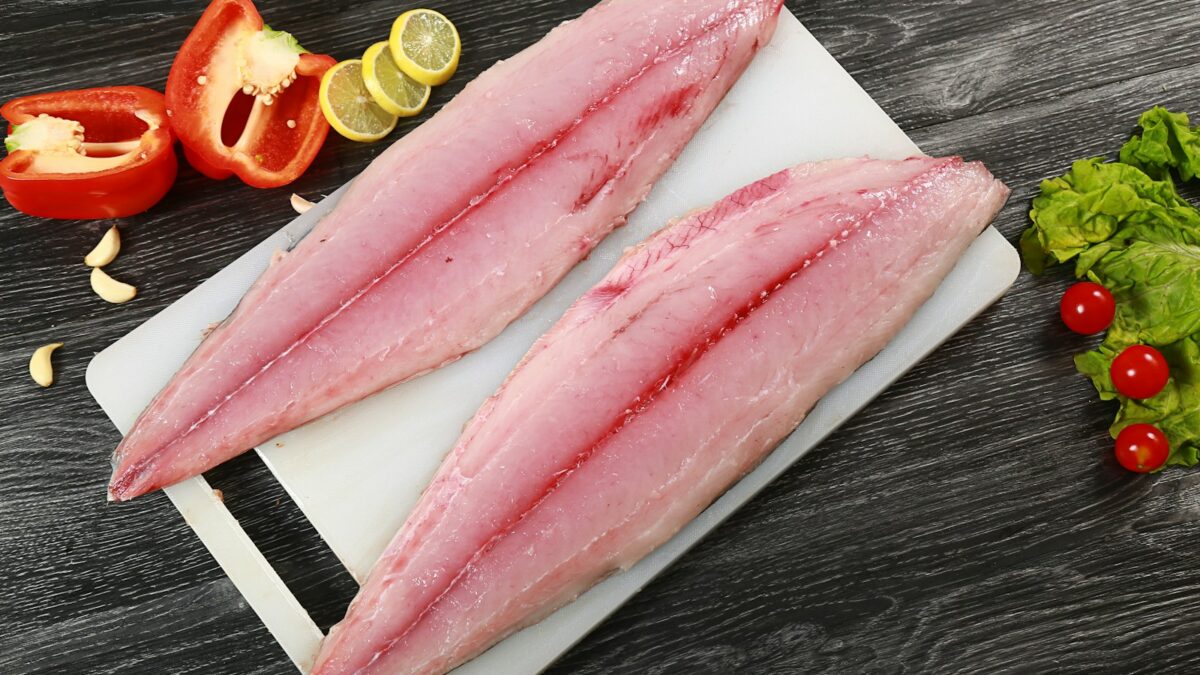 two raw fish fillets on a cutting board