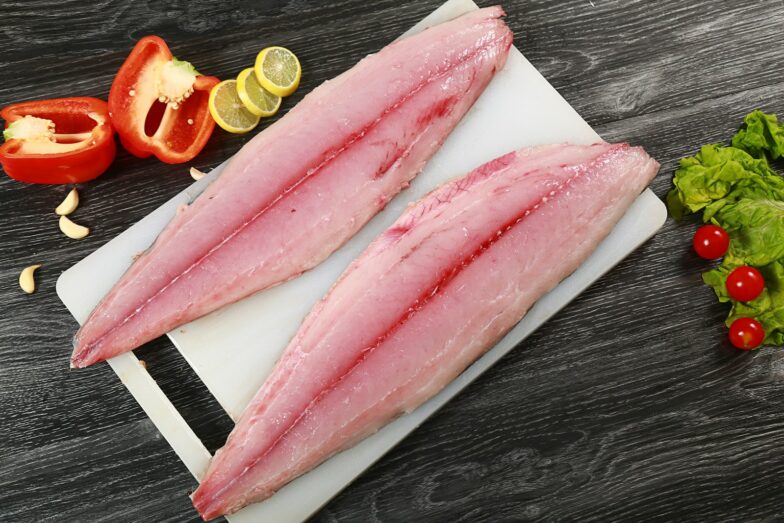 two raw fish fillets on a cutting board