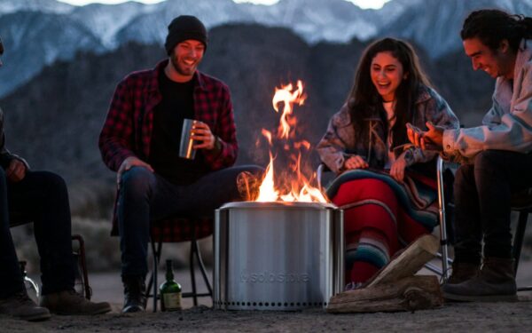 a group of people sitting around a fire pit