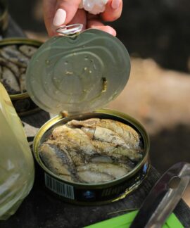 person holding clear glass jar with yellow powder