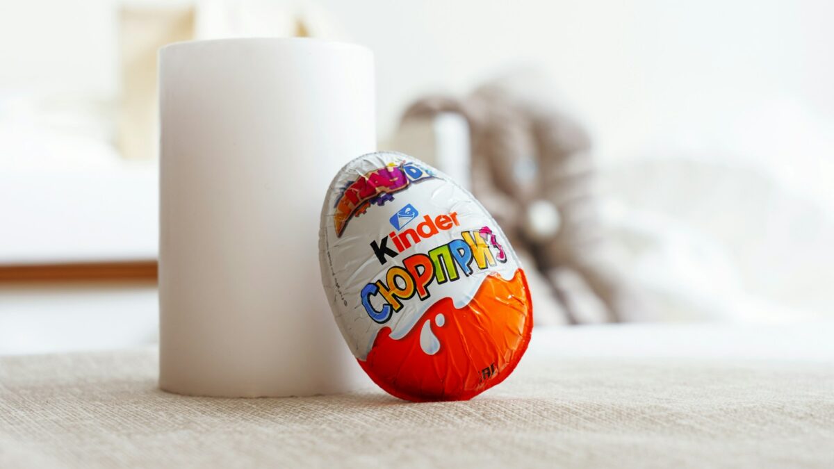 a white cup sitting next to an orange and white egg
