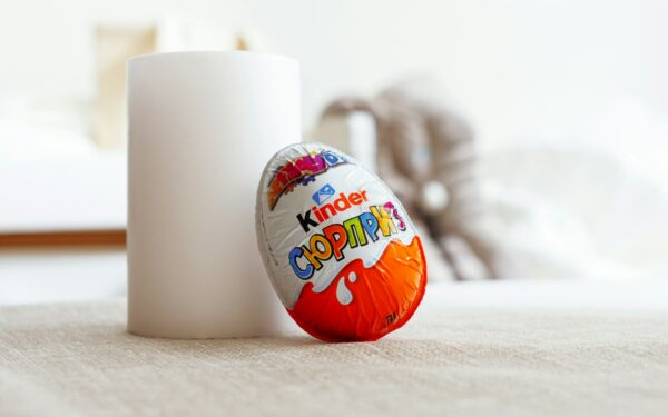 a white cup sitting next to an orange and white egg