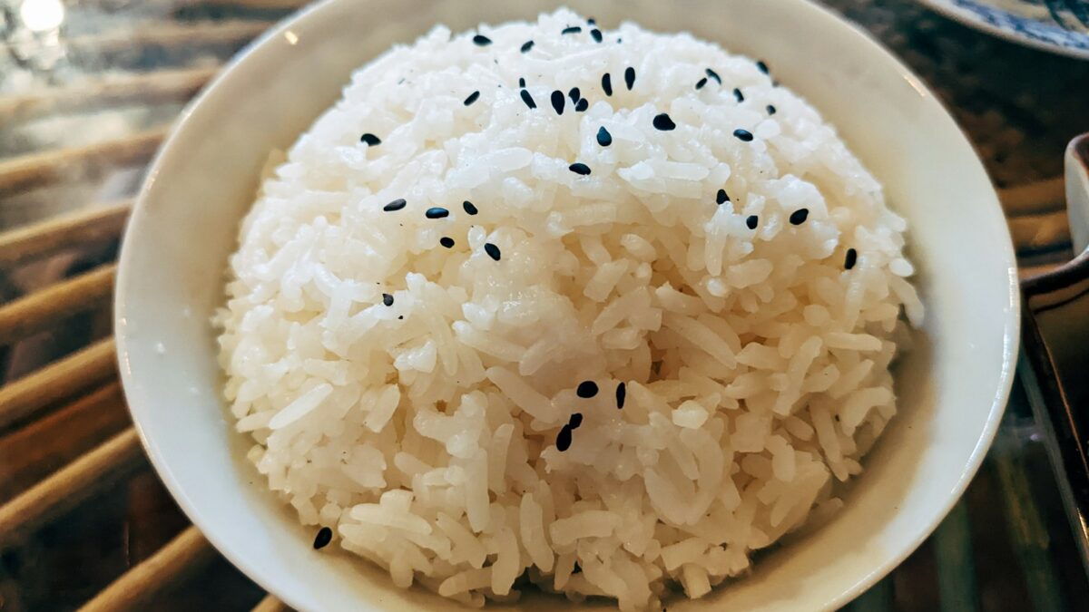 a bowl of white rice with black sesame seeds