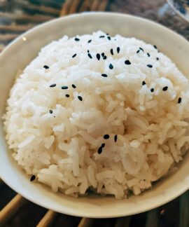 a bowl of white rice with black sesame seeds