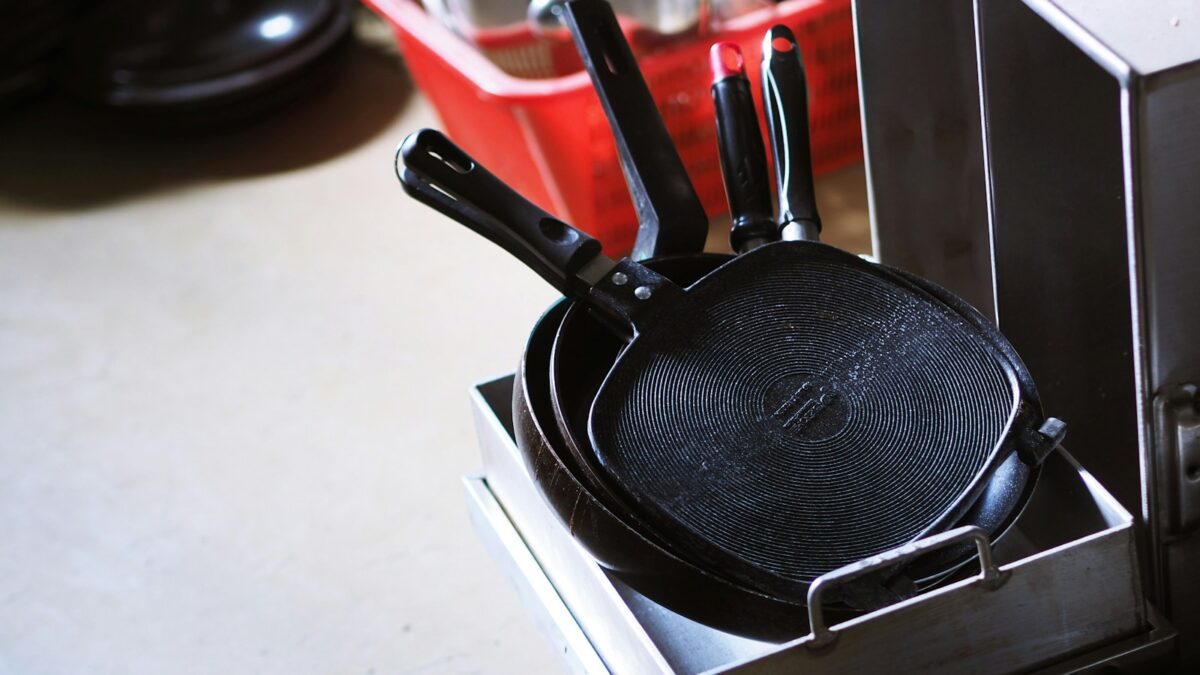black and red handled frying pan on white table