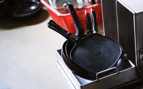 black and red handled frying pan on white table