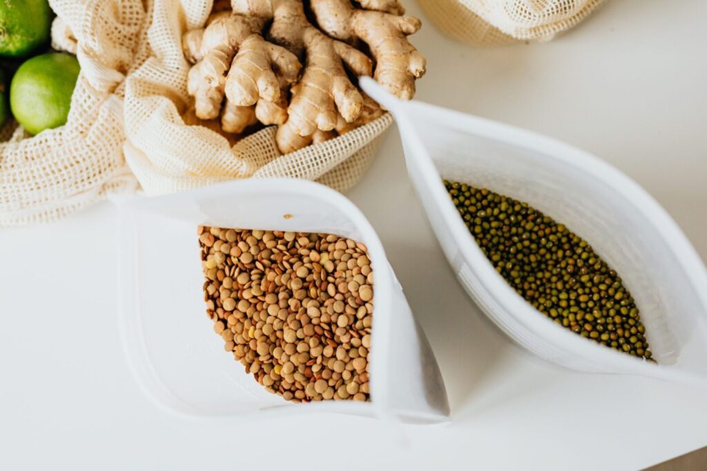 Flat lay of lentils, ginger, and citrus fruit in reusable bags. Perfect for health and sustainability themes.